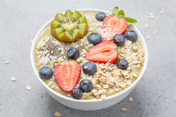 Smoothie bowl with kiwi, banana, Chia seeds, muesli and fresh berries. Healthy breakfast