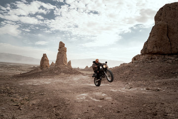 Biker riding motorcycle on desert landscape
