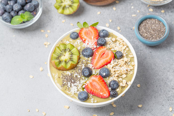 Smoothie bowl with kiwi, banana, Chia seeds, muesli and fresh berries. Healthy breakfast