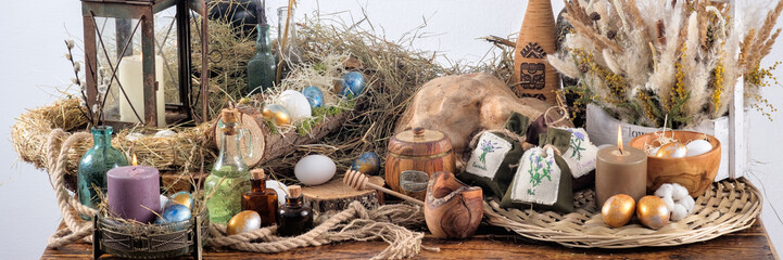 On a wooden table a still life of dried flowers, a sweet table for the holiday. Easter decoration and colored eggs. Easter holiday concept. Banner.