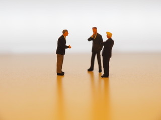 A miniature businessman persuading colleague in the office.