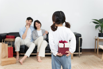 Young Asian mom and dad are unpacking gifts with their daughter