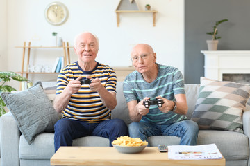 Elderly men playing video games at home