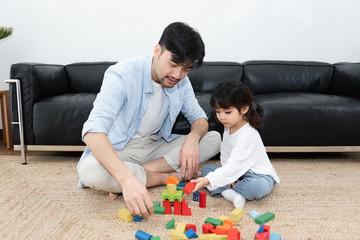 Young Asian mom and dad are building blocks with their daughter