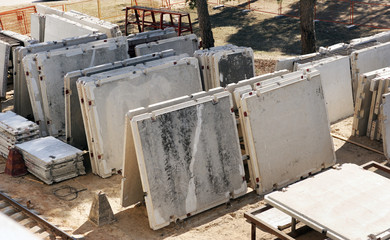 Construction site. Construction of a panel house. The house is at the construction stage. Concrete panels and slabs are folded to the construction site.
