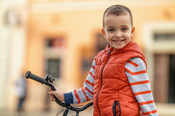 Little boy looking at camera,driving bicycle