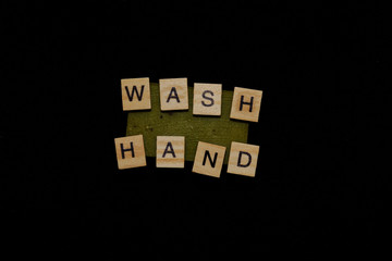 from wooden letters on a piece of olive soap is made the inscription wash your hands.