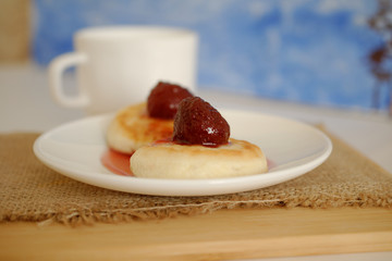 on a white plate cottage cheese top with strawberry jam.