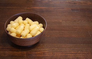 Corn sticks in a clay plate on a wooden table