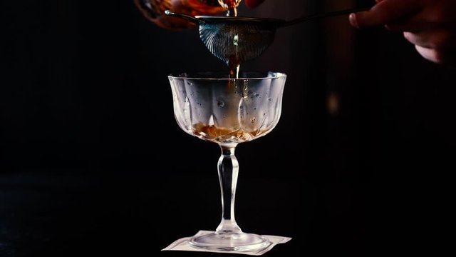 Preparazione di cocktail in coppa di cristallo con sfondo scuro