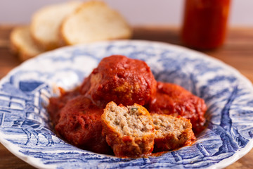Homemade beef meatballs with tomato sauce on wooden table. Italian food.