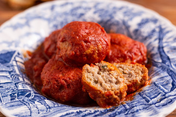 Homemade beef meatballs with tomato sauce on wooden table. Italian food.