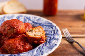 Homemade beef meatballs with tomato sauce on wooden table. Italian food.