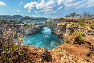 Fototapeta na wymiar Magnificent view of unique natural rocks and cliffs formation in beautiful beach known as Angel's Billabong beach located in the east side of Nusa Penida Island, Bali, Indonesia. Aerial view.