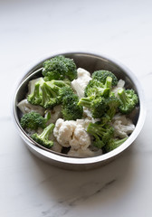 Broccoli and cauliflower on white marble background