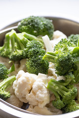 Broccoli and cauliflower on white marble background