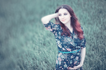 Pregnant girl in a dress in nature