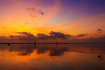 Burning bright sky during sunset on a tropical beach. Sunset during the exodus, the strength of people walking on water
