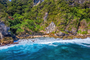 Magnificent view of unique natural rocks and cliffs formation in beautiful beach known as Atuh Beach located in the east side of Nusa Penida Island, Bali, Indonesia. Aerial view.