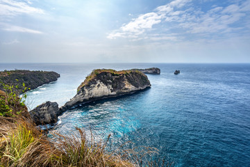 Magnificent view of unique natural rocks and cliffs formation in beautiful beach known as Atuh Beach located in the east side of Nusa Penida Island, Bali, Indonesia. Aerial view.