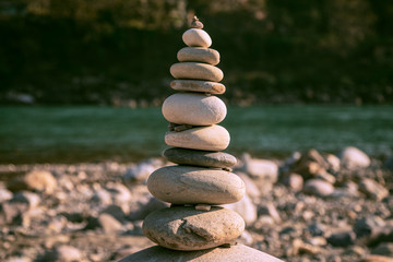 Zen like stone tower balance concept close up Pyramid of stones on the beach Ganga River, beautiful rest and vacation concept, panoramic view