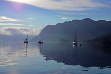 Fototapeta na wymiar Sailboats Moored On Lake Against Sky During Sunset