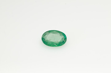 Natural green emerald oval shape on the white background