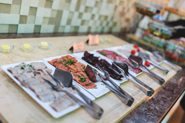 Beautifully designed buffet table in the hotel restaurant with sliced meat on plate