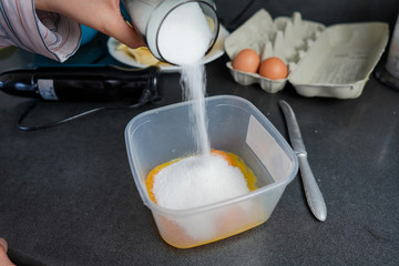 Mixing eggs with sugar. Preparation of the dough for baking homemade pie. Cooking cake at home. Baking during quarantine