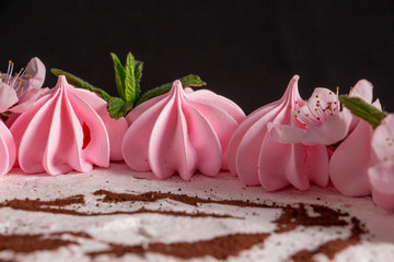 Pink marshmallow cake on a black background with a painted machine