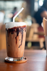 Iced mocha coffee with chocolate cream poured into glass it showing the texture