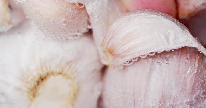 The unpeeled garlic under water with air bubbles.