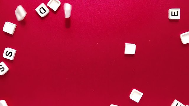 Top View of letter tile falling on red surface. Concept. Slow Motion
