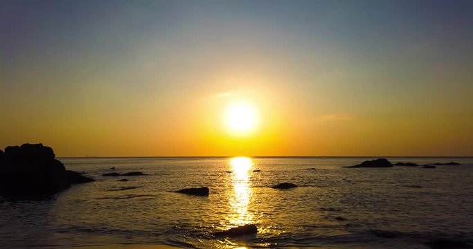Timelapse of beautiful dramatic sunset over sea or ocean with dramatic sky and colorful fluffy clouds. 4K time lapse clip