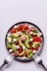 Vegetarian salad with avocado, grapefruit, tomato, feta cheese and arugula. Healthy nutrition. Selective focus