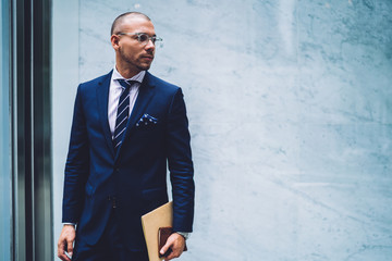 Calm pensive adult employee in light modern office