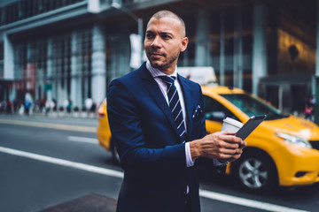  Businessman using tablet while walking on street