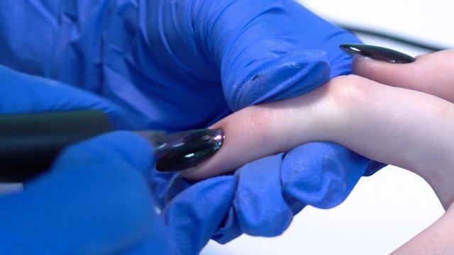 Closeup view 4k video of professional colorful glossy brilliant holiday manicure at fingers of young woman. Modern trendy shiny amazing cat eye effect nail design on black gelpolish.