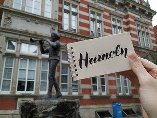 The Pied Piper of Hameln is the most famous German legend.This photo shows a statue in his hometown Hamelin, Lower Saxony, Germany. View with calligraphic inscription "Hameln". Mobile photography.