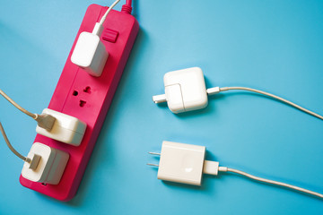 Pink extension power strip with only one socket left while there are 2 white mobile charger await...