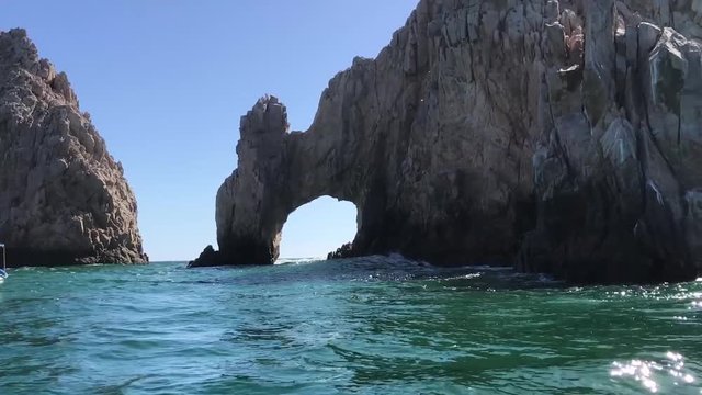 A boat approaching to the famous rock arch at Los Cabos.