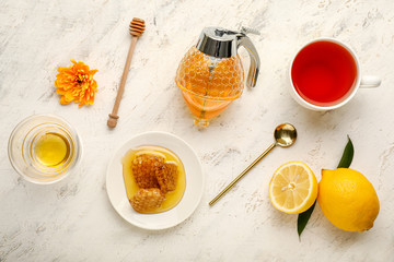 Jar of sweet honey with tea and lemon on white background