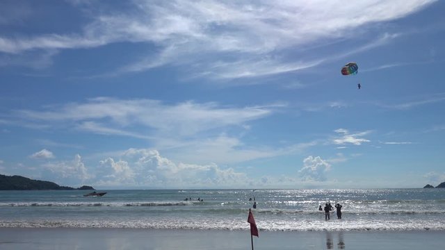 Parasailing in Patong beach, famous beach that full of tourists and a lot of activities, located in Phuket, Thailand.