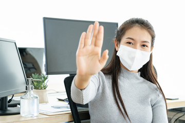 Attractive Asian young woman ware mask show hand stop or outbreak and looking camera during video conference meeting group working from home, corona virus or covid-19 spread social distancing concept.