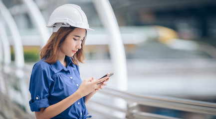 Woman Engineer using smartphone talking to friend and standing capital downtown