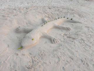 gecko made of sand on the seashore. sand figure