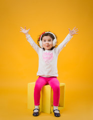Girl with headphones on a yellow background