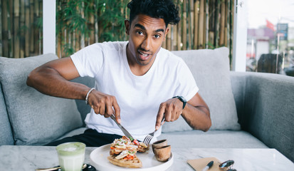 Hispanic adult man eating on balcony