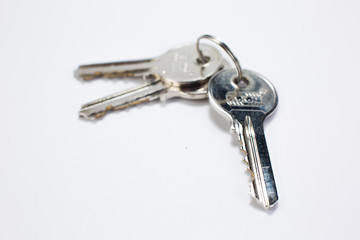 Many brass and chrome old keys on white table. Security and encryption, concept image.