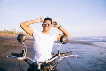 Cheerful biker smiling on sea coast